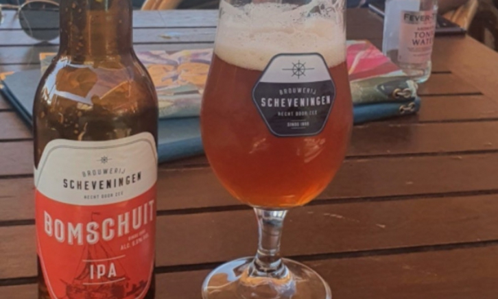 bomschuit ipa van brouwerij scheveningen glas en flesje op tafel op een terras